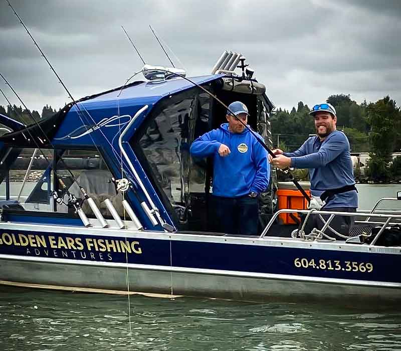 Two Men fishing for sturgeon on a boat in the river.