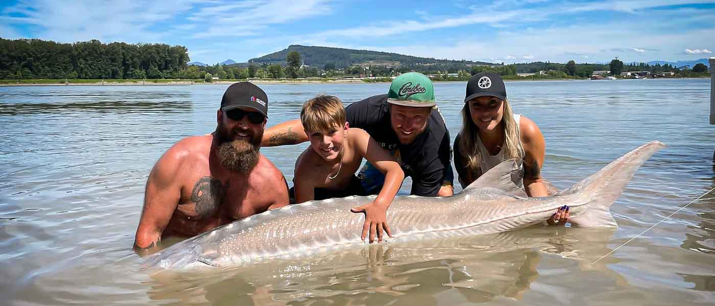 Family holding a Sturgeon that was caught in the Fraser River