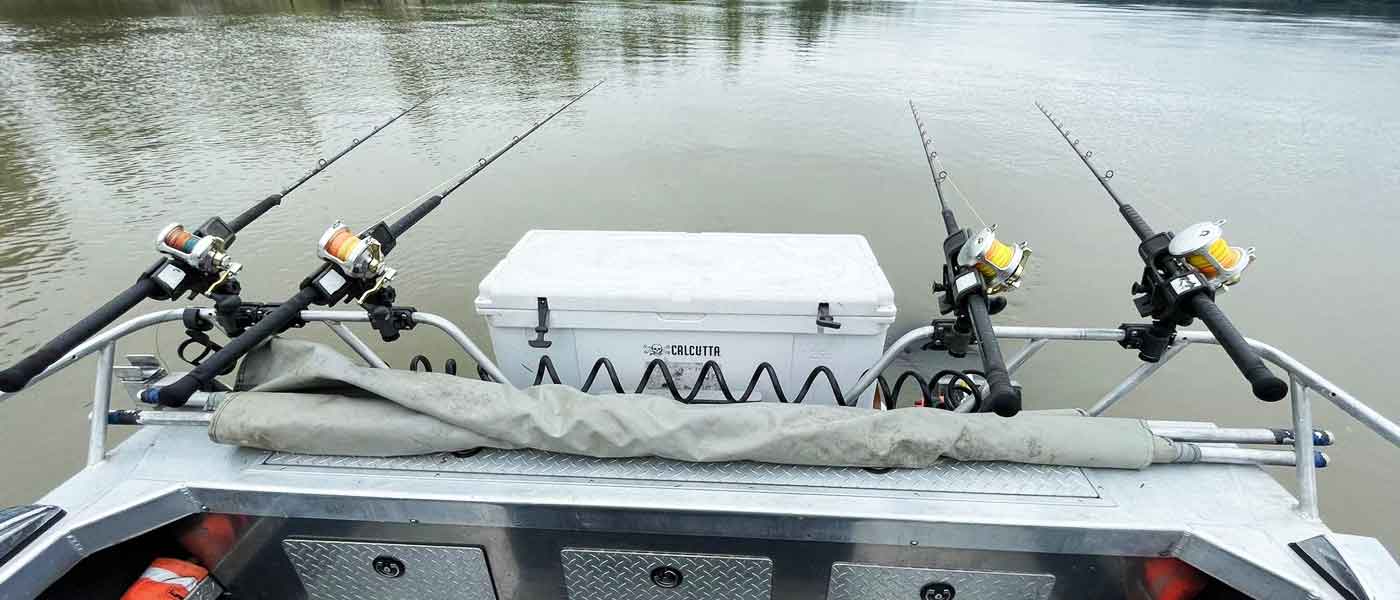 4 Fishing rods out in the water off the back of a boat. - It's Sturgeon Season in BC!